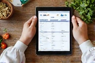 Manos diseñando un plan de comidas en una tableta